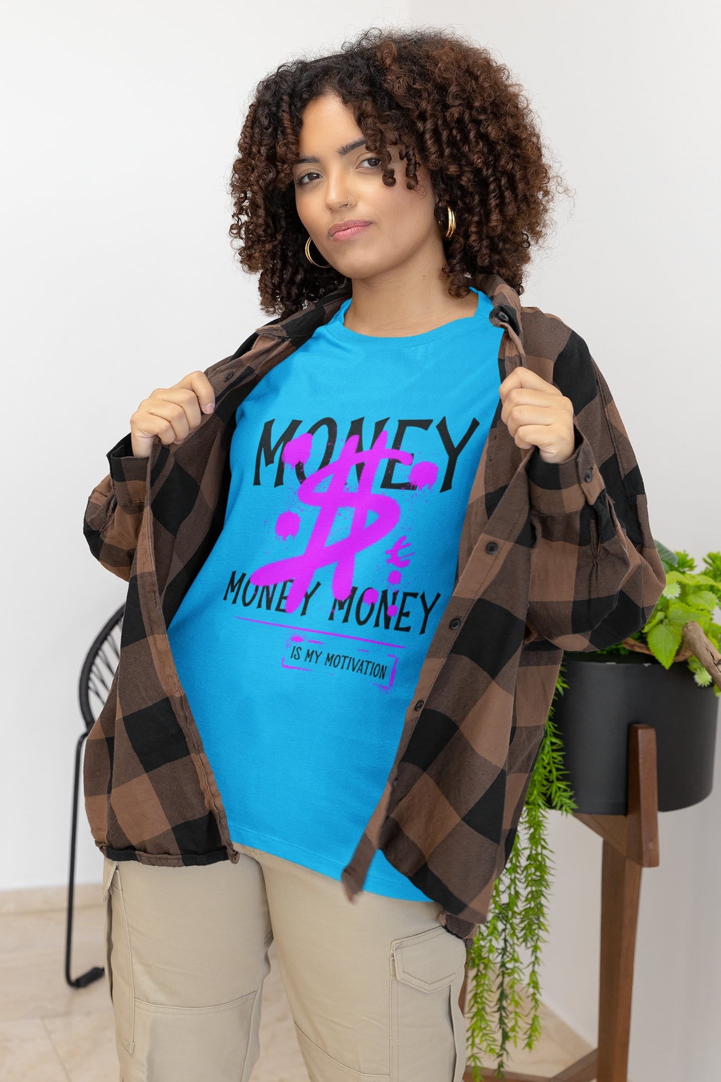Person wearing a blue t-shirt with text and a plaid shirt over shoulders against a white background