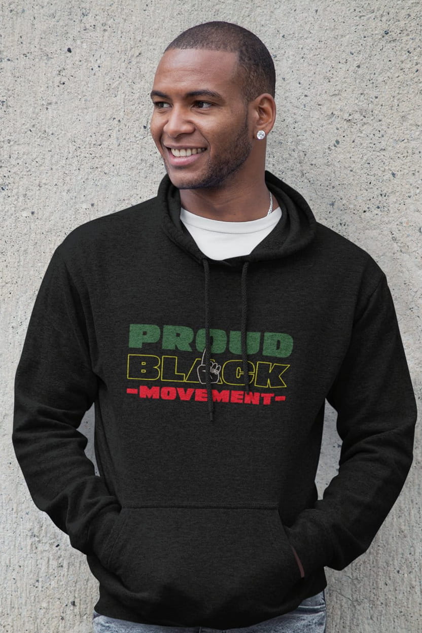 Man wearing a black hoodie with 'Proud Block Movement' text against a concrete wall.