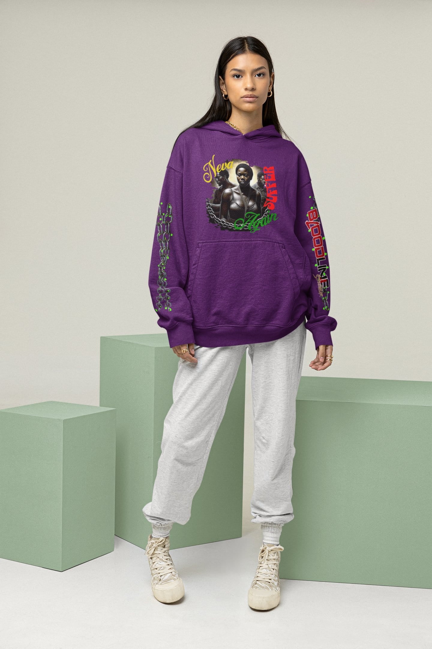 Person wearing a purple hoodie with graphic designs on a neutral background