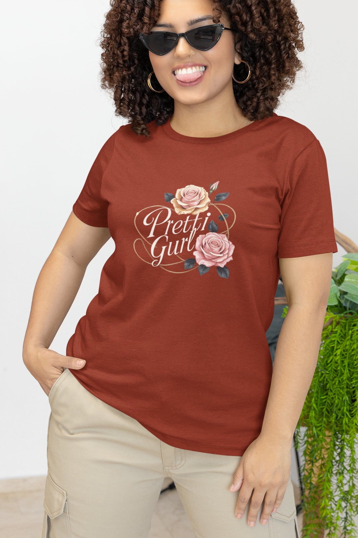 Woman wearing a red t-shirt with 'Pretty Girl' and floral design, standing outdoors.