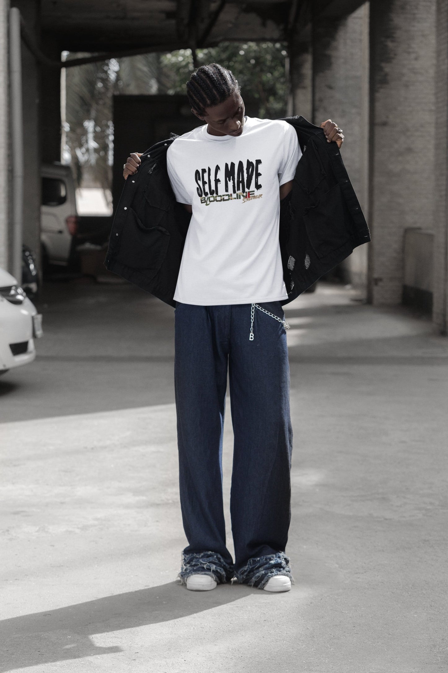 Person wearing a 'Self Made' t-shirt in an urban setting