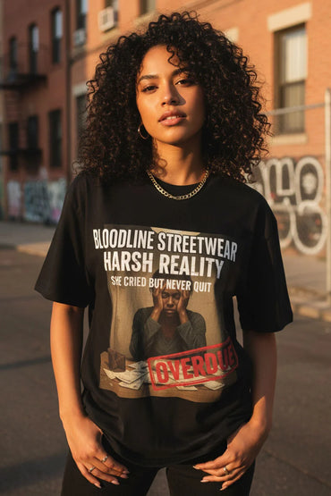 Woman wearing a black t-shirt with graphic design and text, standing on a street.