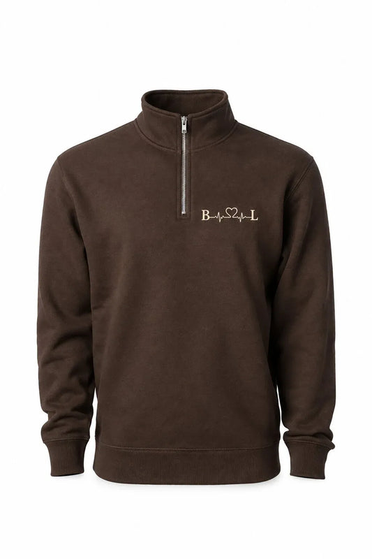 A dark brown long-sleeve quarter-zip sweatshirt with a mock neck collar, featuring a small gold embroidered 'BSL' logo on the left chest, displayed on a clean white background.