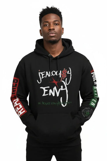 A man wearing a black pullover hoodie with 'Jealous Envy' printed in white and red on the front, featuring red text on one sleeve and green text on the other, against a plain white background.