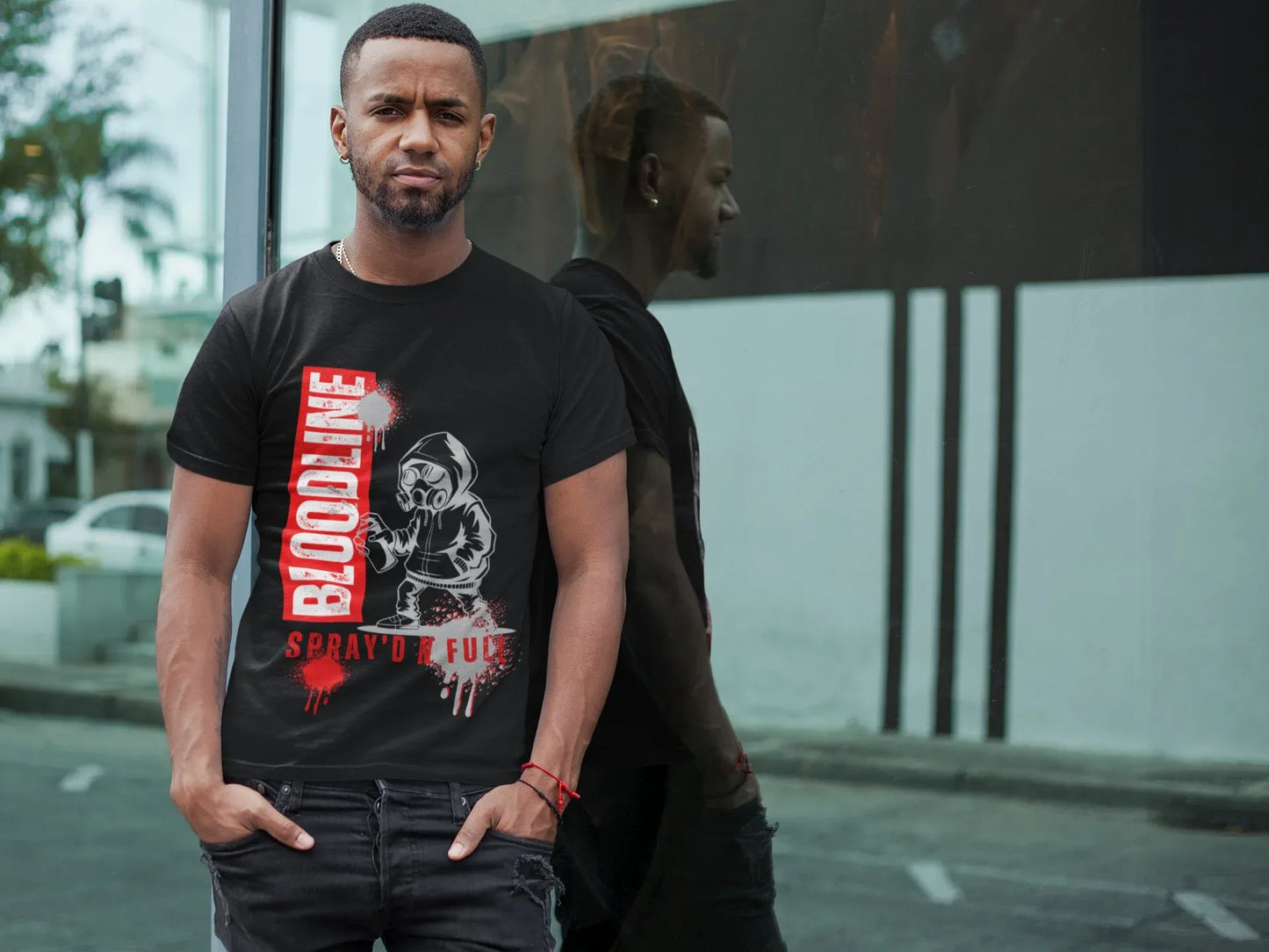 Man wearing a black t-shirt with graphic design and text on a city street.