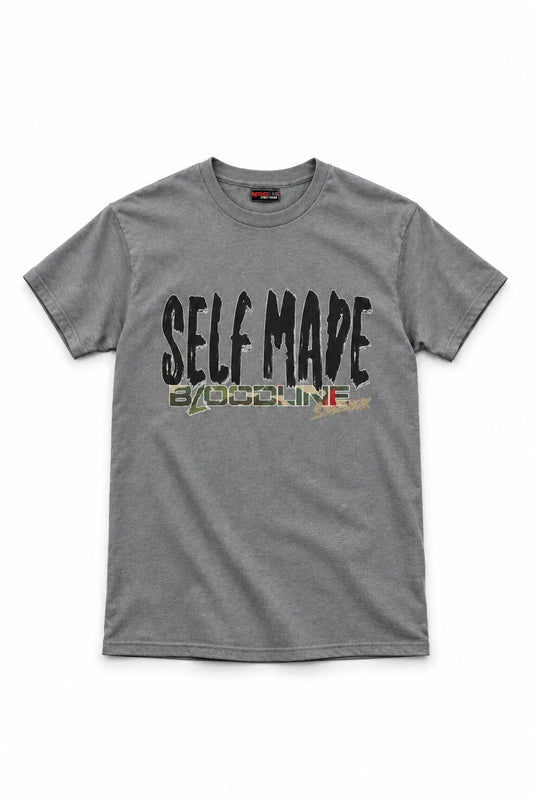 A heather gray crewneck t-shirt featuring a distressed graphic print on the front that reads 'SELF MADE' in black, with 'BY OSOLINE' underneath in a green, yellow, and red patterned design.