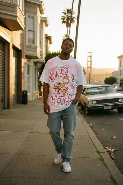 Male model wearing Can't B Lokd SouLethal Hand-Painted Tee by Bloodline Streetwear walking on a city sidewalk