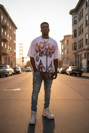 Person wearing a graphic t-shirt and jeans standing on a city street.