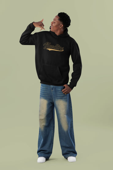 Person wearing a black hoodie with a logo and blue jeans on a light green background