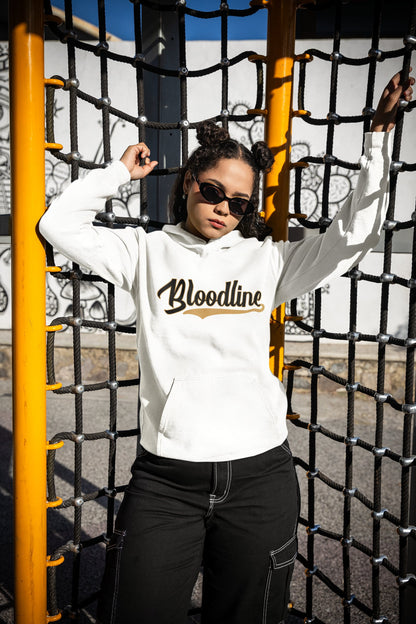 Person wearing a white hoodie with 'Bloodline' text, standing behind a yellow and black metal fence.