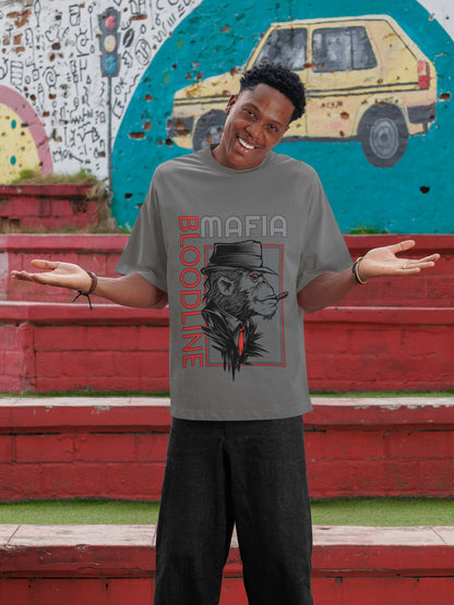 Person wearing a gray t-shirt with a graphic design in front of a colorful mural.