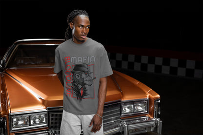 Man wearing a gray t-shirt with a graphic design in front of a classic car.