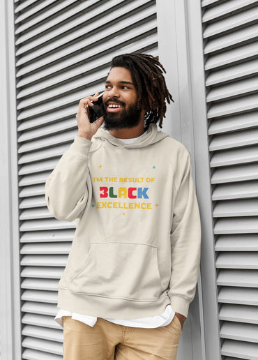 Man wearing a hoodie with 'Black Excellence' text, standing against a textured wall.
