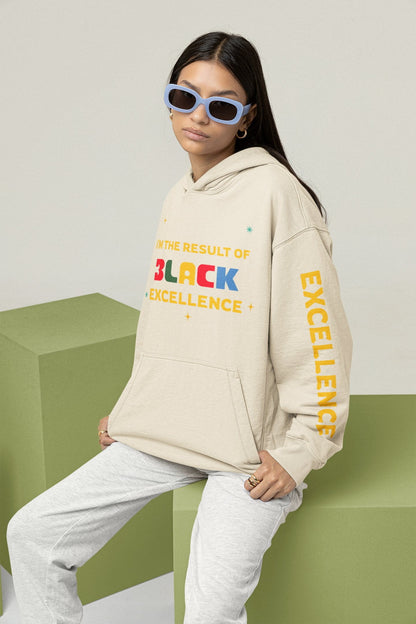 Person wearing a beige hoodie with 'Black Excellence' text, sitting on a green block.