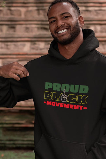 Man wearing a black hoodie with 'Proud Black Movement' text against a brick wall.