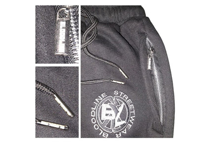 Gray pants with zippers and a brand logo on a white background