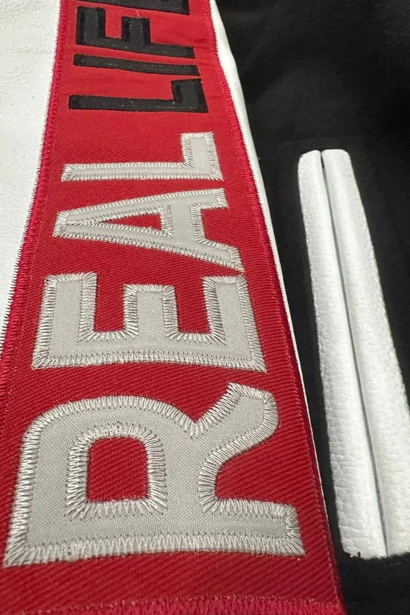 Red belt with 'REALIFE' embroidery on a black background