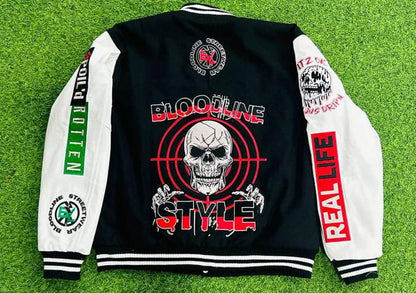 Black and white varsity jacket with graphic designs and text on a grass background