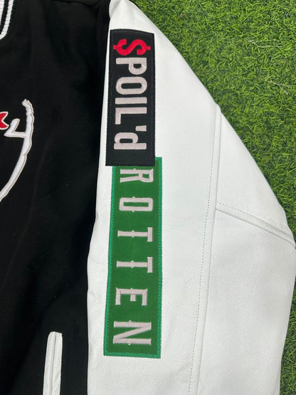 Black and white jacket with 'Spoil'd Rotten' text on a grass background