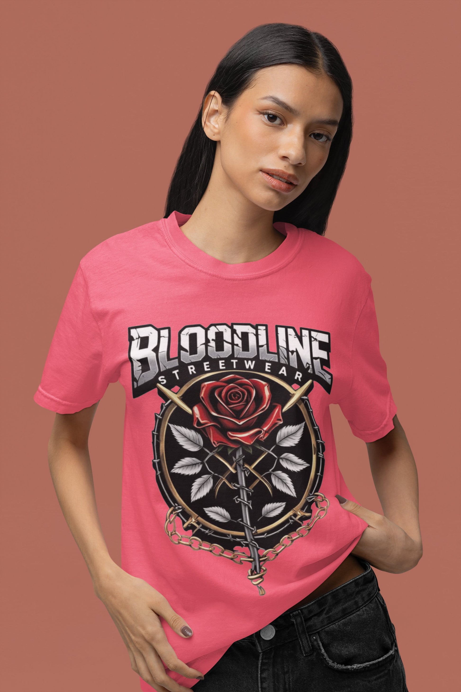 Person wearing a pink t-shirt with 'Bloodline Streetwear' design on a brown background