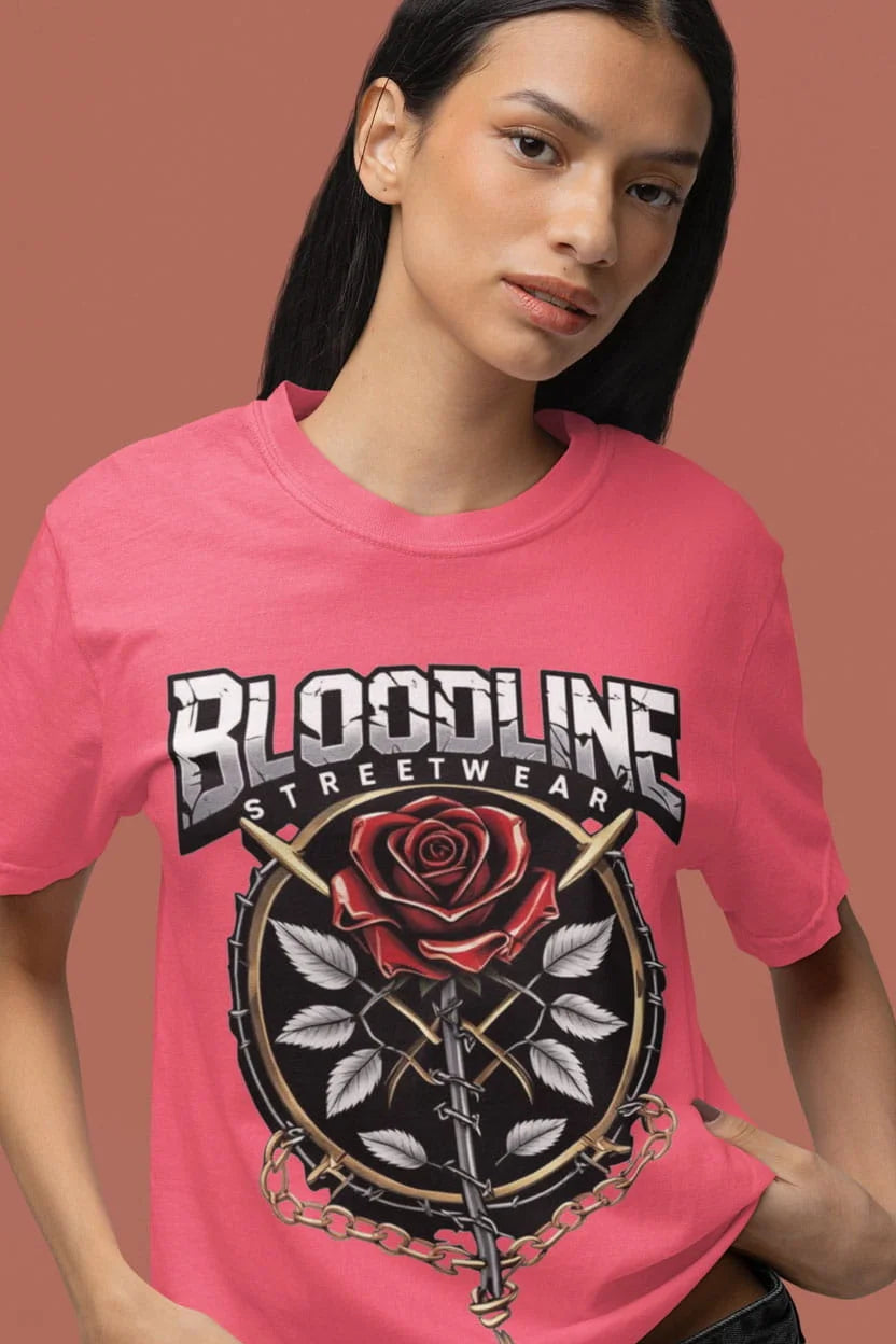 Person wearing a pink 'Bloodline Streetwear' t-shirt with a rose design on a brown background