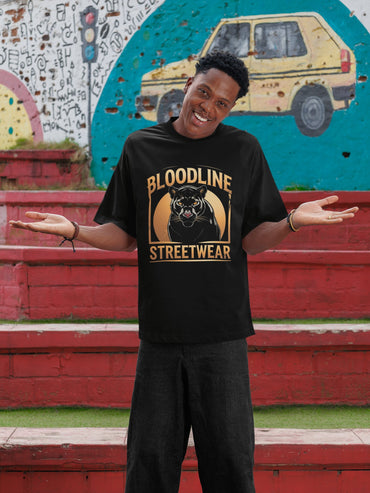 Person wearing a 'Bloodline Streetwear' t-shirt with a panther graphic in front of a colorful mural.