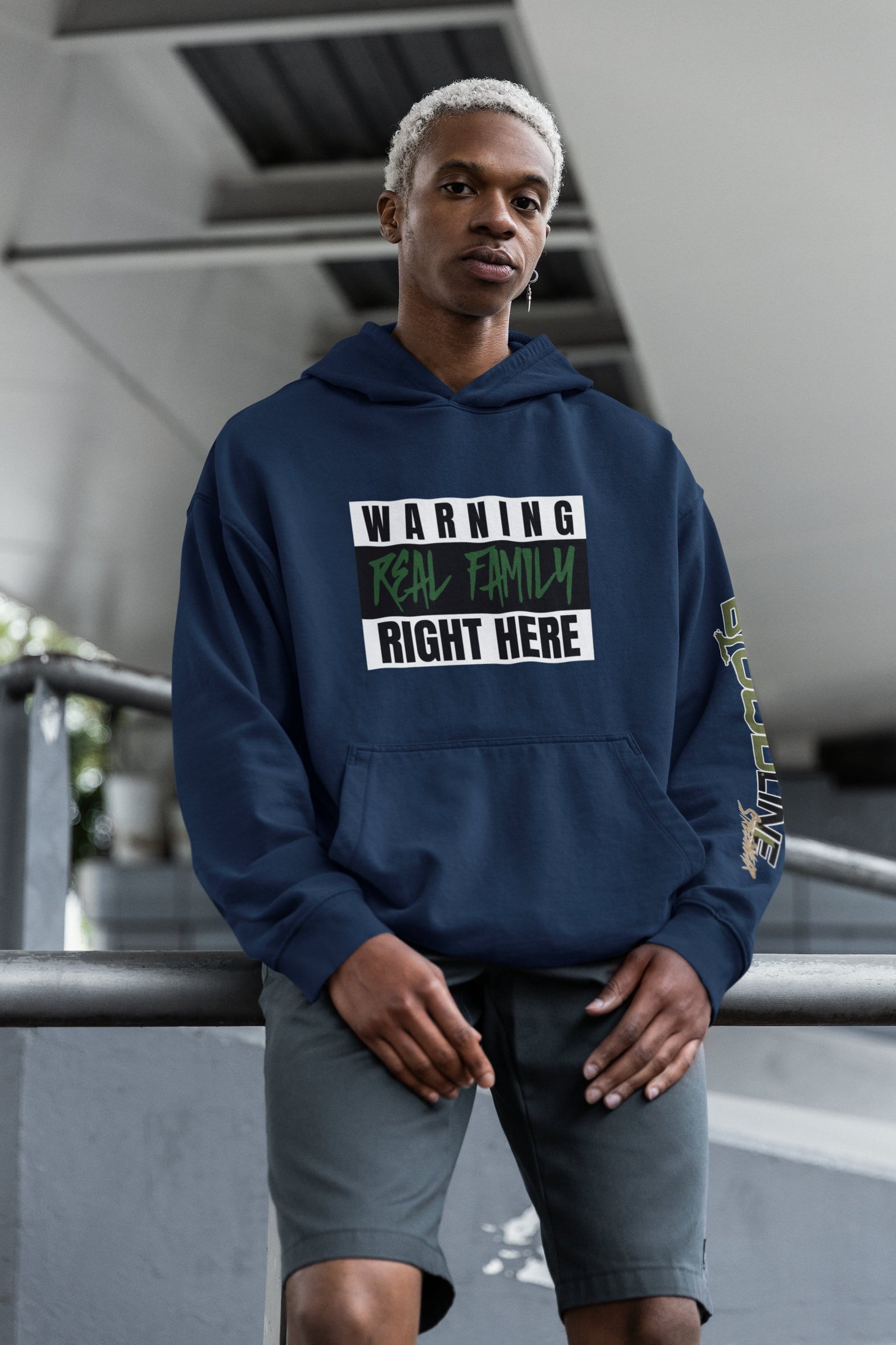 Person wearing a navy blue hoodie with text in an urban setting