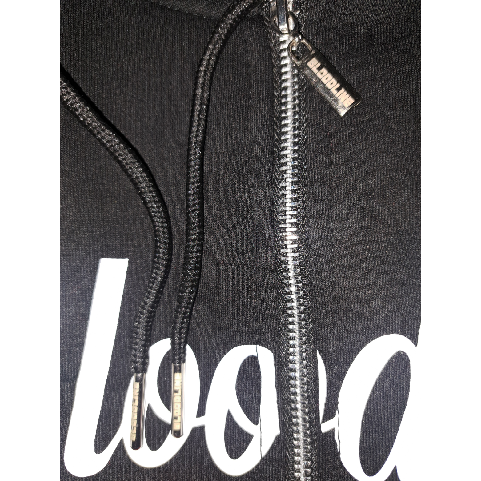 Bloodline zipper with white text and a zipper, featuring a brand logo on the chest.