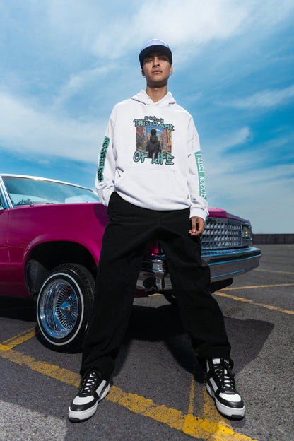 Person wearing a white hoodie with graphic design in front of a pink car on a clear day.
