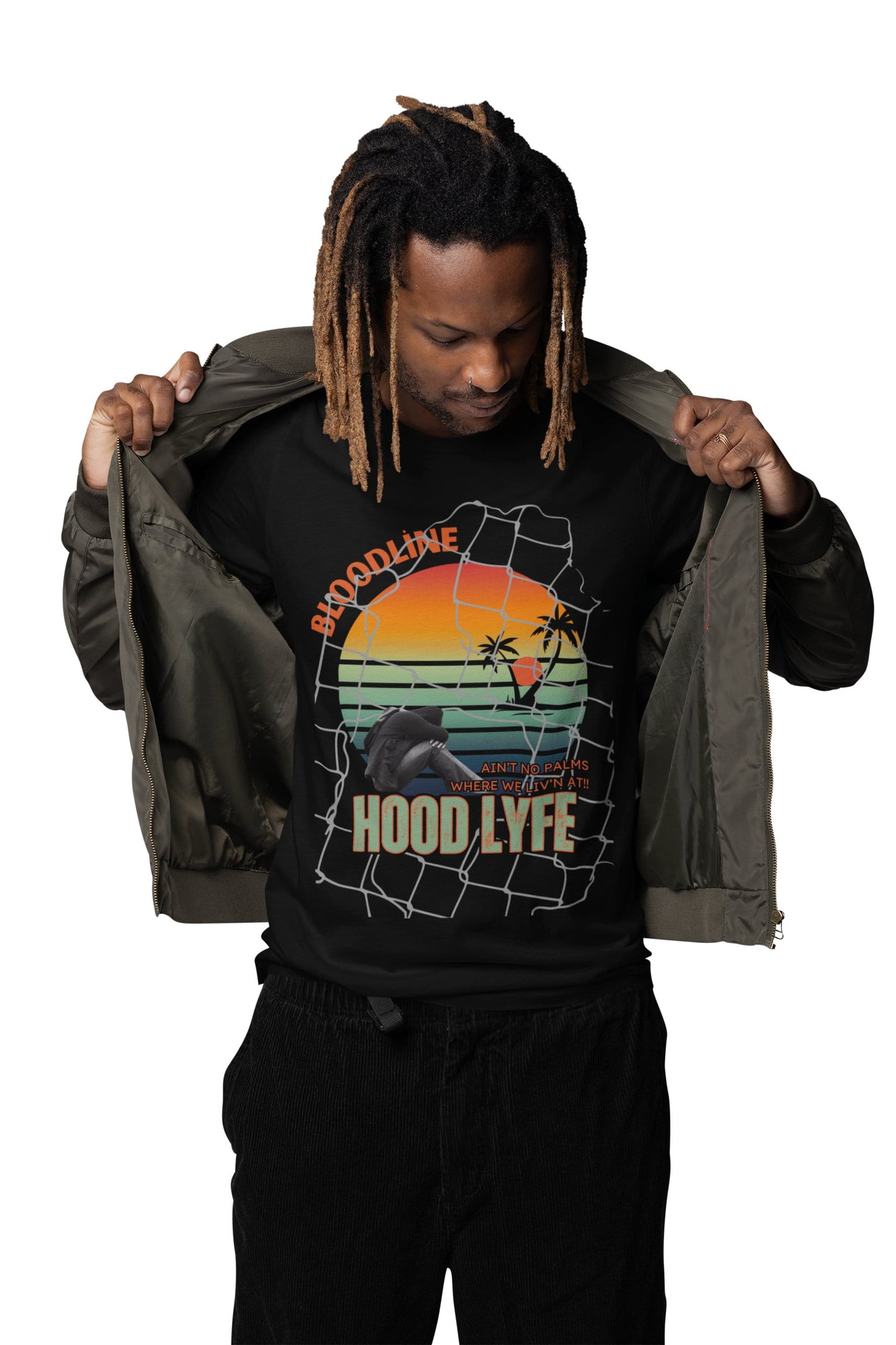 Person wearing a black hoodie with a graphic design and text, holding a green jacket.