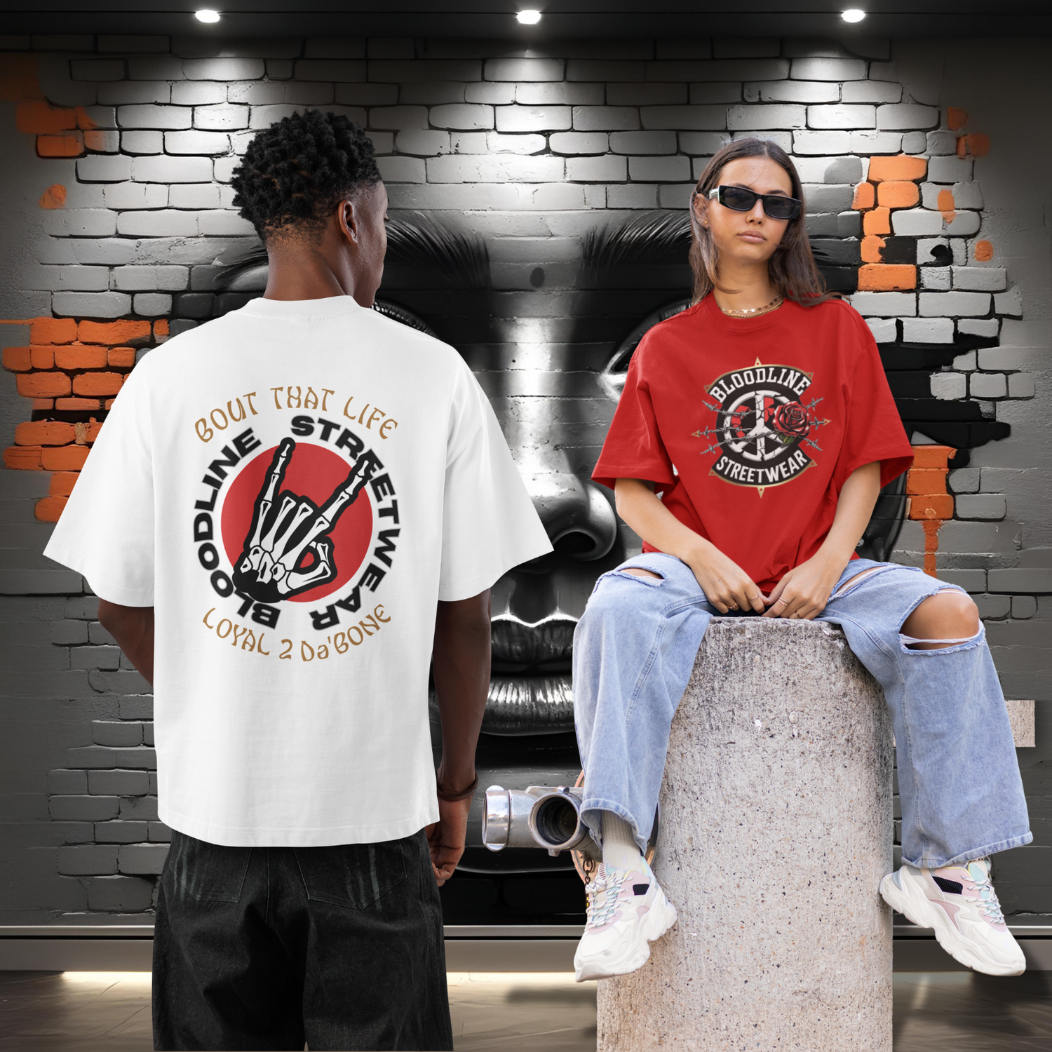 Two people wearing t-shirts with visible branding against a brick wall background