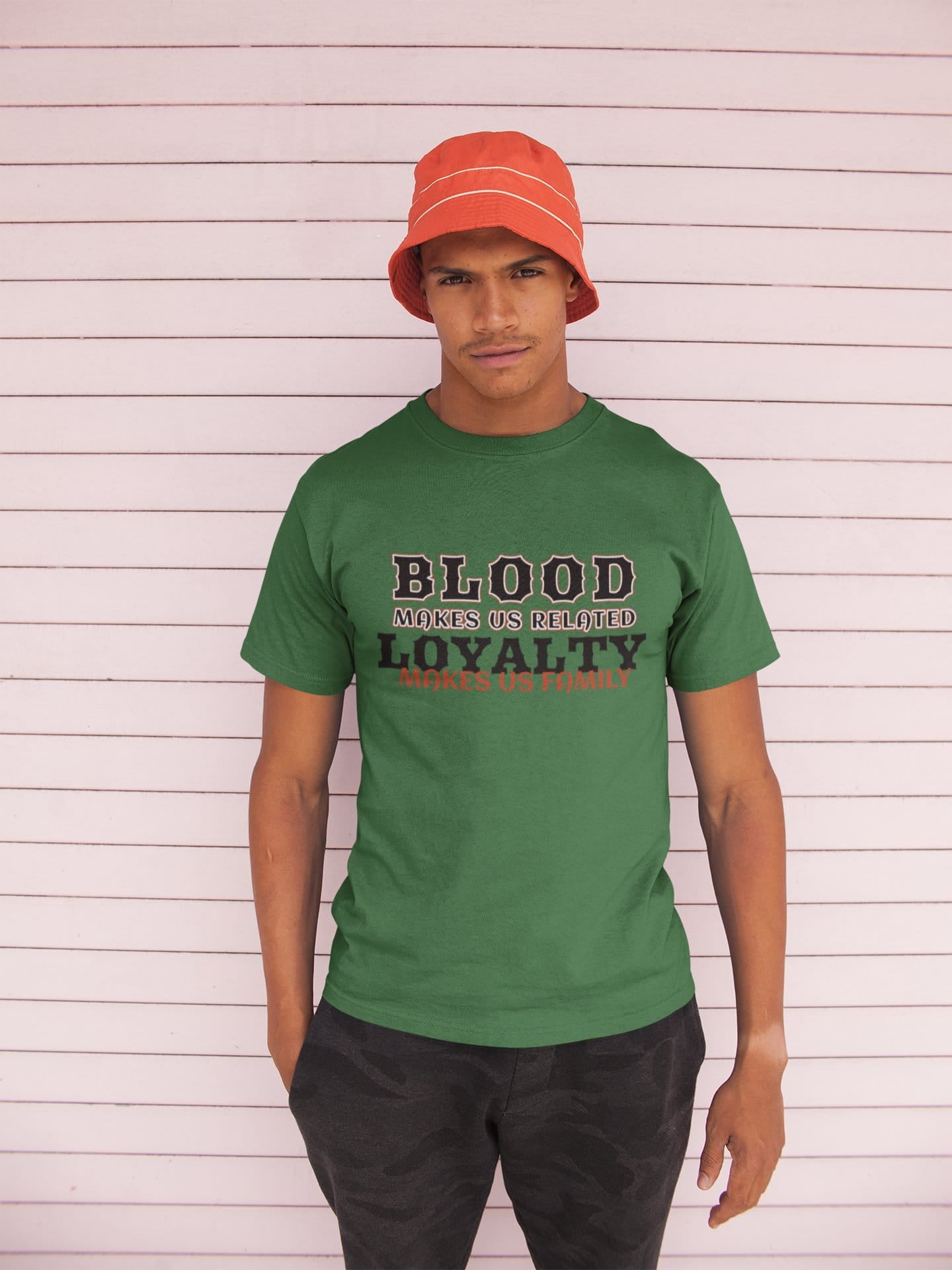 Person wearing a green t-shirt with text and a red bucket hat against a white background