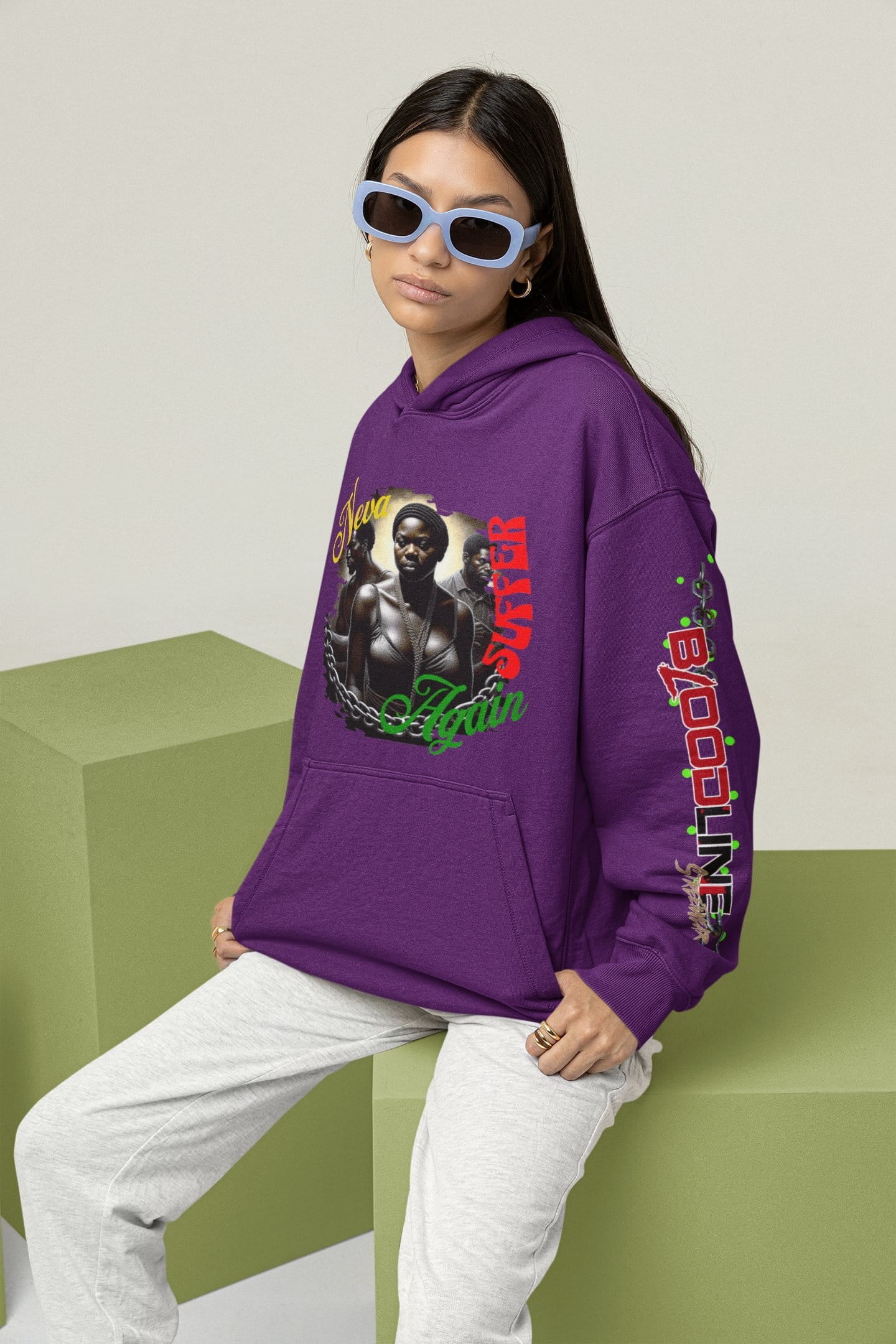 Person wearing a purple hoodie with graphic design on a light background
