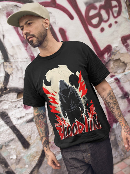 Man wearing a black t-shirt with a graphic design in front of a graffiti-covered wall.