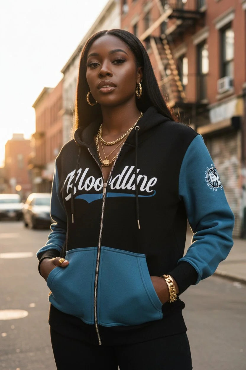 Woman wearing a black and blue hoodie with 'Bloodline' branding on a city street.