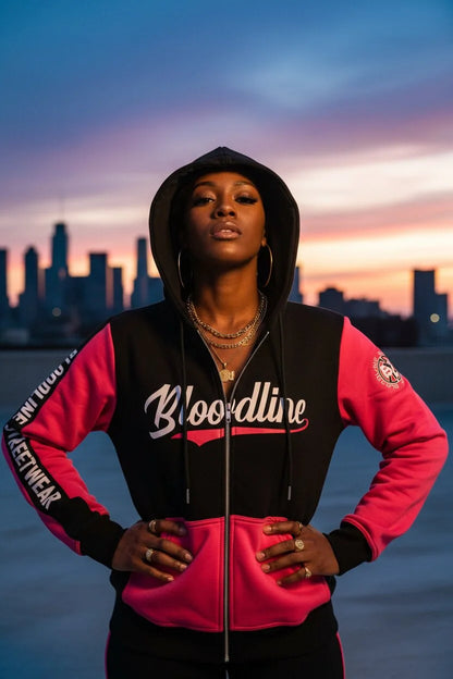 Person wearing a black and pink 'Bloodline' hoodie with a city skyline in the background.