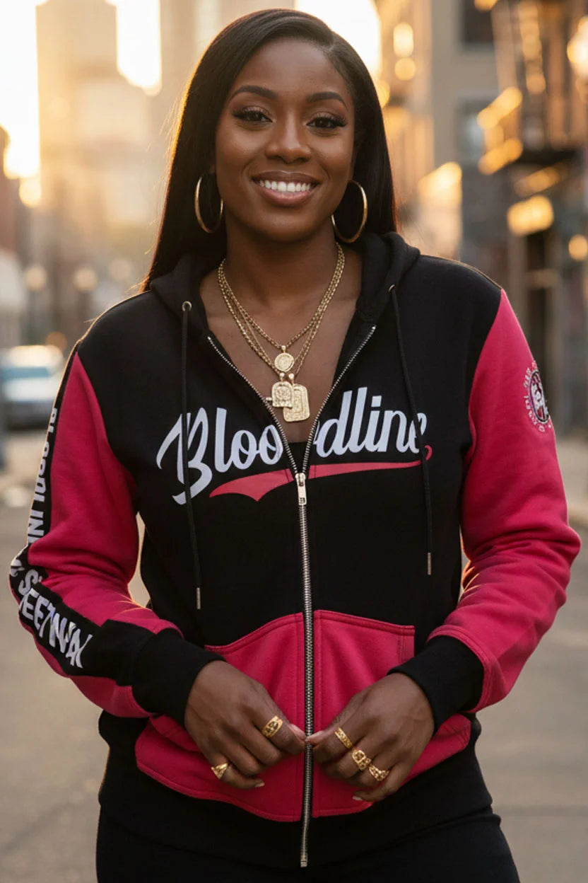 Woman wearing a black and red hoodie with 'Bloodline' text, standing outdoors.