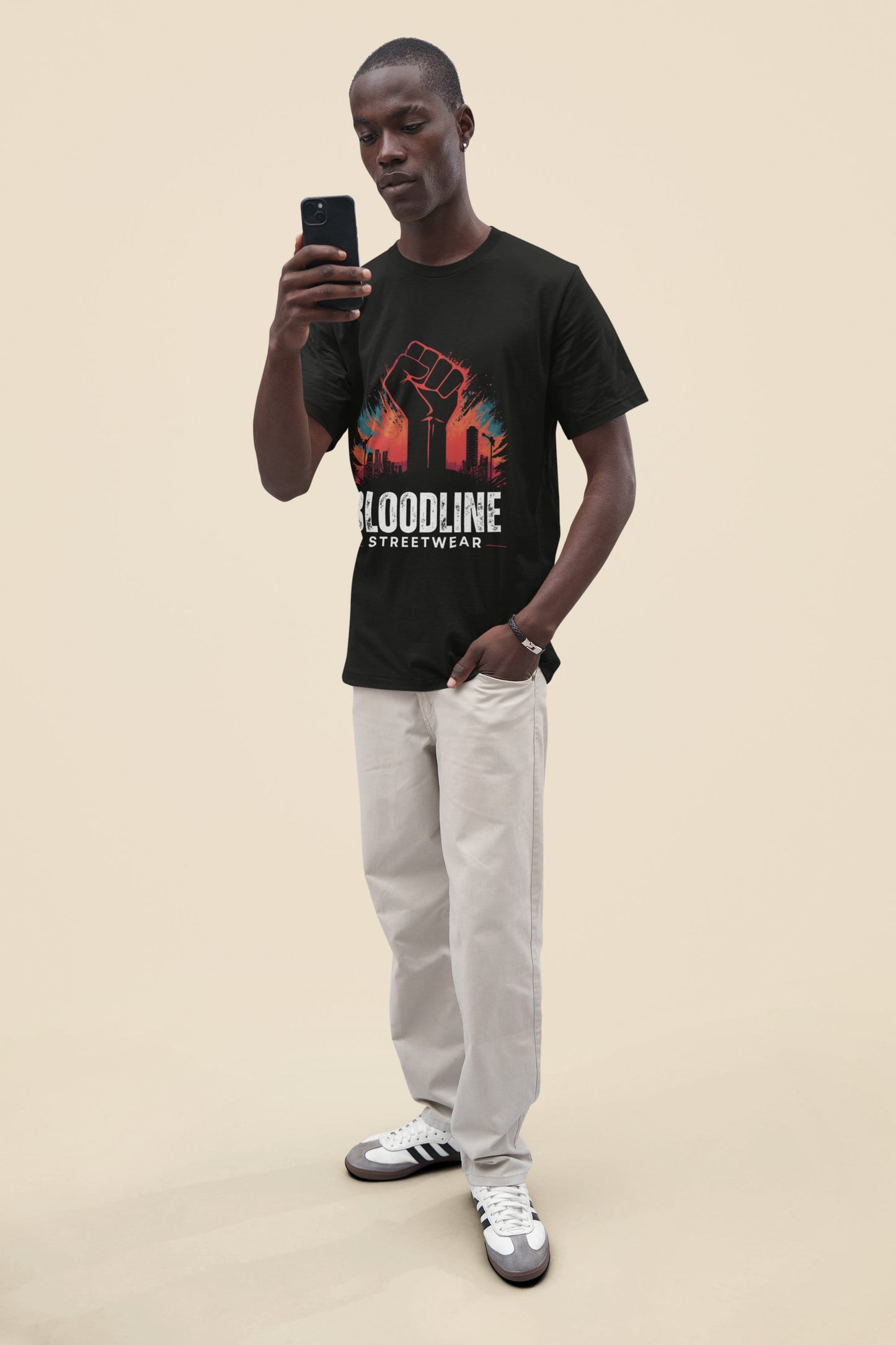 Man wearing a black t-shirt with colorful graphic design and text, standing against a beige background.