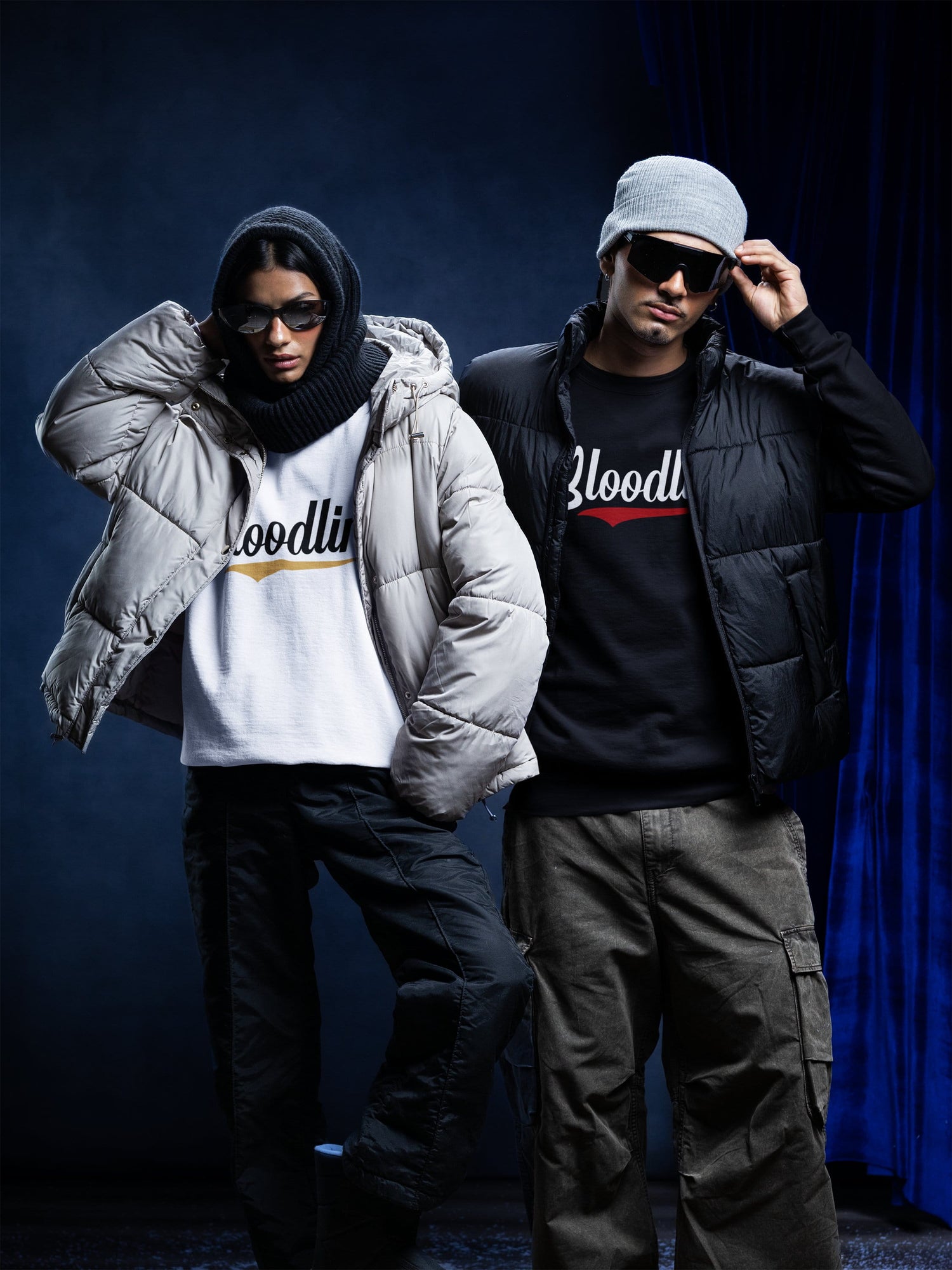 Two people wearing branded clothing against a dark background