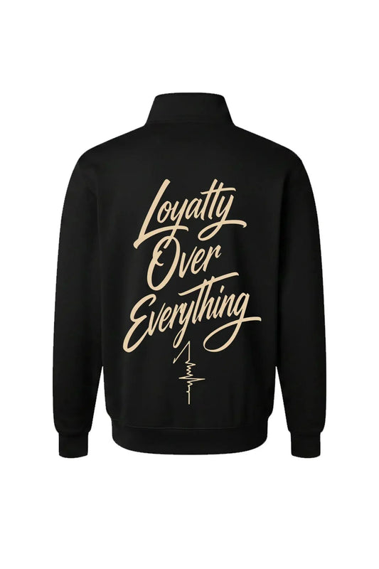 A black long-sleeve quarter-zip jacket shown from the back, featuring the phrase 'Loyalty Over Everything' printed in a large beige cursive font with a small vertical signature graphic below it.