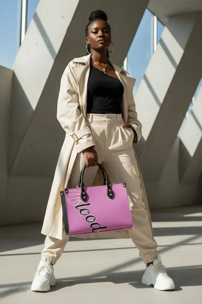 A woman stands in a modern architectural setting with concrete beams, holding a bright pink tote bag with black handles and the word 'LOVE' printed on it. She is wearing a beige trench coat, beige pants, a black top, and white sneakers.