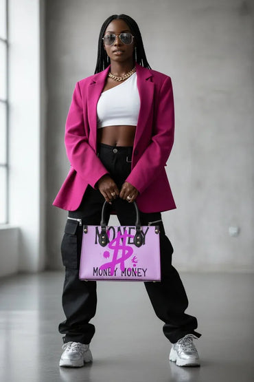 A woman stands in a minimalist gray indoor space wearing a bright magenta blazer, white crop top, black cargo pants, and white sneakers, holding a pink handbag with bold black and magenta text that reads 'MONEY MONEY'.