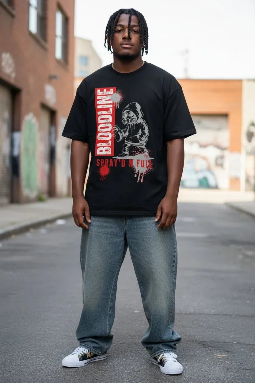 A man wearing a black graphic t-shirt with a red and white 'BLOODLINE' design, paired with light blue jeans and white sneakers, standing in an urban alleyway.